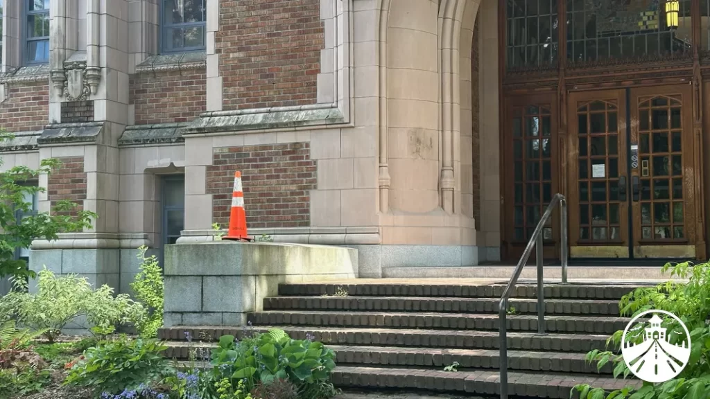 Current photo of Miller Hall at the University of Washington from the same angle as Professor Miller’s exit in Rose Red, with a traffic cone where the lamp post stood.